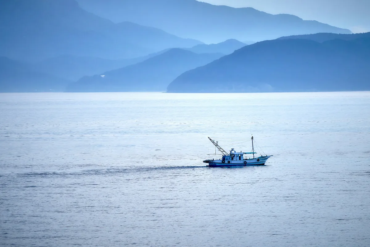 A fishing boat crossing the calm Seto Inland Sea in Japan
